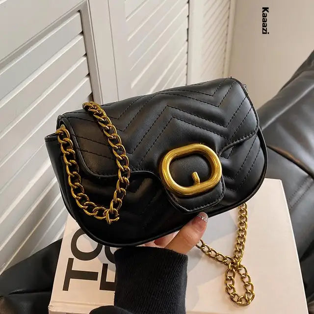 Black quilted luxury minimalist leather bag with gold chain strap and oval buckle flap closure