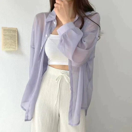 Woman wearing sheer lavender button down lightweight sun protection shirt over white crop top and ribbed drawstring pants
