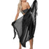 Back view of model holding black sheer ruffle summer beach wrap skirt tied at waist for coverage